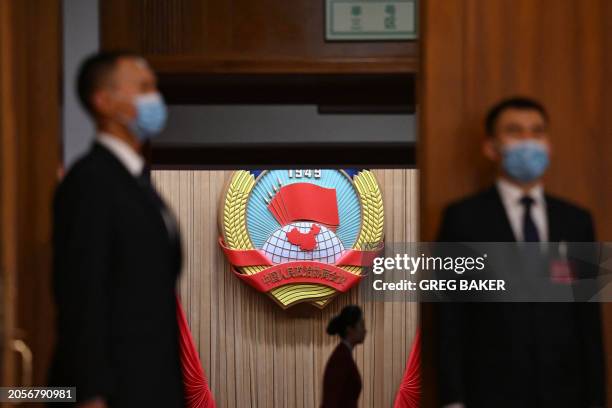 Security guards wait at an entrance before the second plenary session of the Chinese People's Political Consultative Conference at the Great Hall of...