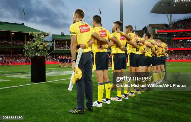 Umpires pause in memory of Jesse Baird and Luke Davies during the 2024 AFL Opening Round match between the Sydney Swans and the Melbourne Demons at...