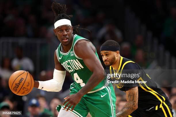 Jrue Holiday of the Boston Celtics dribbles past Gary Payton II of the Golden State Warriors during the second quarter at TD Garden on March 03, 2024...