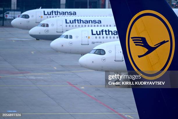 The logo of German airline Lufthansa can be seen on the vertical stabilizer of a plane standing with other Lufthansa aircrafts at the airport in...