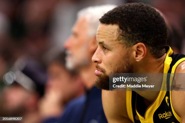 Stephen Curry of the Golden State Warriors looks on from the bench during the first quarter against the Boston Celtics at TD Garden on March 03, 2024...