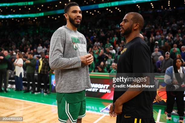 Jayson Tatum of the Boston Celtics talks with Chris Paul of the Golden State Warriors at TD Garden on March 03, 2024 in Boston, Massachusetts. The...