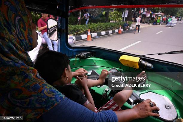 This picture taken on January 30, 2024 shows Bajaj driver and single mother Ekawati, who plies her three-wheeled taxi in a profession overwhelmingly...