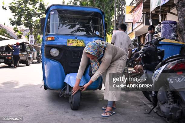 This picture taken on February 2, 2024 shows Bajaj driver and single mother Ekawati, who plies her three-wheeled taxi in a profession overwhelmingly...