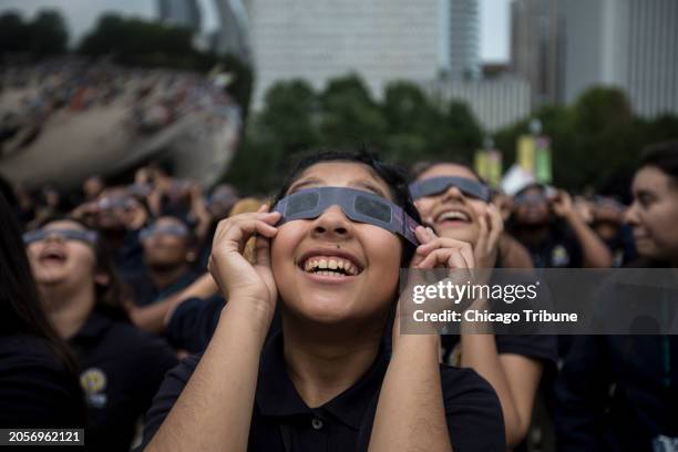 Students from Muchin College Prep react as the solar eclipse emerges from behind clouds in Millennium Park in Chicago on Aug. 21, 2017.