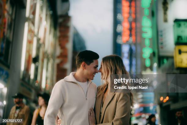 young couple having a good time in tokyo at night - city life authentic stockfoto's en -beelden