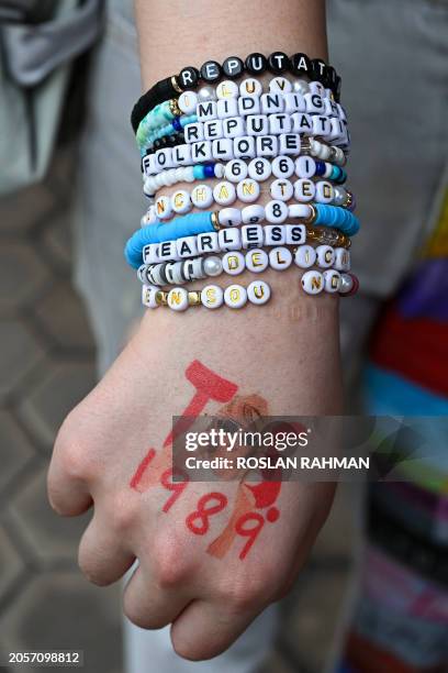 Fan of US singer Taylor Swift, also known as a Swiftie, displays friendship bracelets as they arrive for the pop star's Eras Tour concert at the...