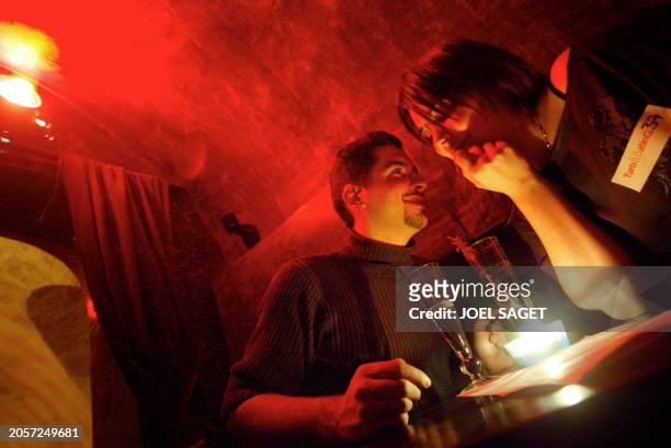 Un homme et une femme font connaissance dans un bar de Paris, le 13 février 2003, dans le cadre d'une soirée de "speed dating" organisée par l'agence...