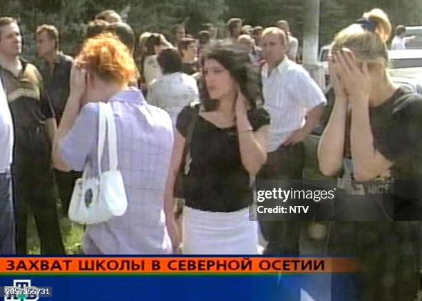 This TV grab image taken from Russian NTV channel, 01 September 2004 shows anxious women standing outside the school where a group of extremists...