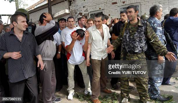 Men cry during the rescue operation in Beslan's school, northern Ossetia, 03 September 2004. Dozens of corpses of dead hostages are currently inside...