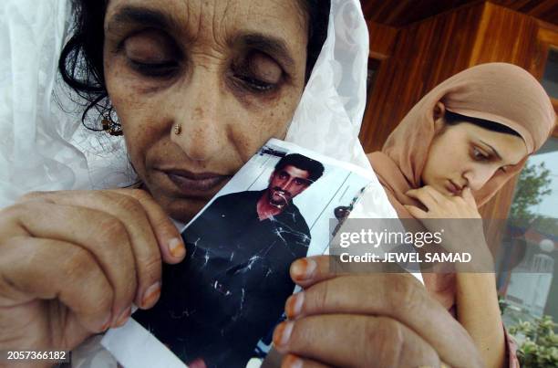 Zarina Naeem , the mother of Pakistani national Sajjad Naeem, displays a picture of her son as her daughter Ruma Naeem stands next to her in...