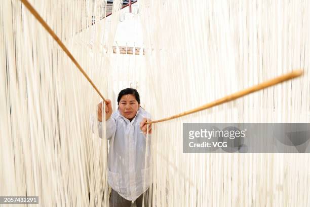An employee hangs the unique handmade hallow noodles to dry at a workshop on March 3, 2024 in Sihong County, Suqian City, Jiangsu Province of China.