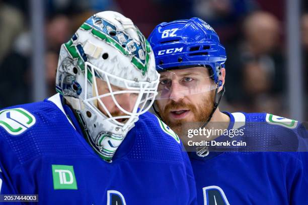 Thatcher Demko and Ian Cole of the Vancouver Canucks wait for a face-off during the second period of their NHL game against the Pittsburgh Penguins...