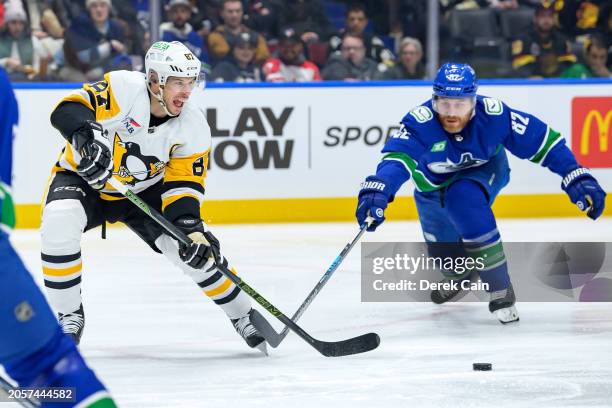 Sidney Crosby of the Pittsburgh Penguins plays the puck ahead of Ian Cole of the Vancouver Canucks during the second period of their NHL game at...