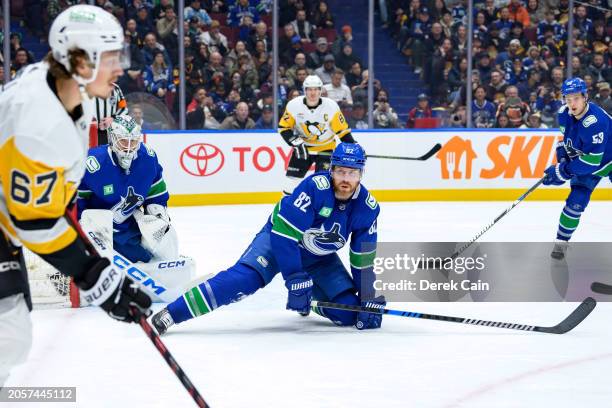 Ian Cole and Thatcher Demko of the Vancouver Canucks defend against Rickard Rakell of the Pittsburgh Penguins during the second period of their NHL...