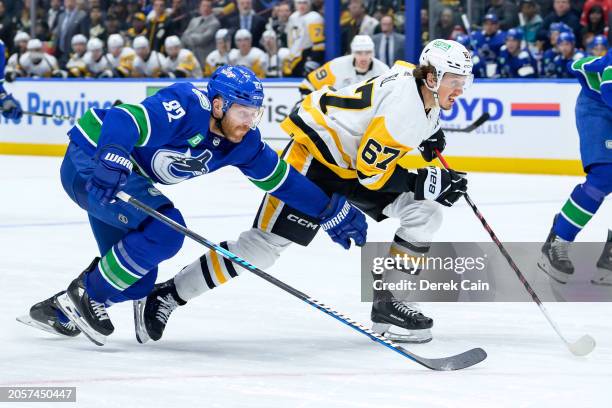 Ian Cole of the Vancouver Canucks defends against Rickard Rakell of the Pittsburgh Penguins during the third period of their NHL game at Rogers Arena...