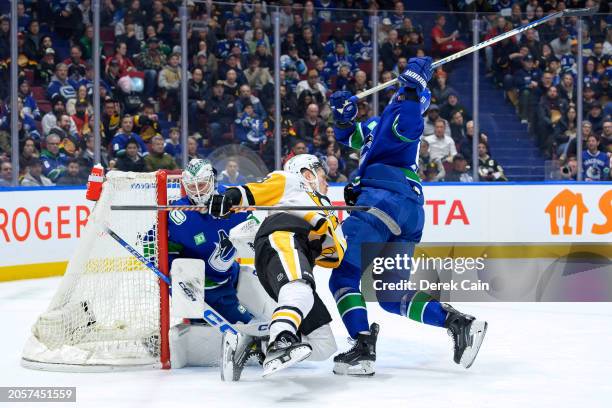 Jesse Puljujarvi of the Pittsburgh Penguins is checked by Nikita Zadorov as Thatcher Demko of the Vancouver Canucks looks on during the second period...