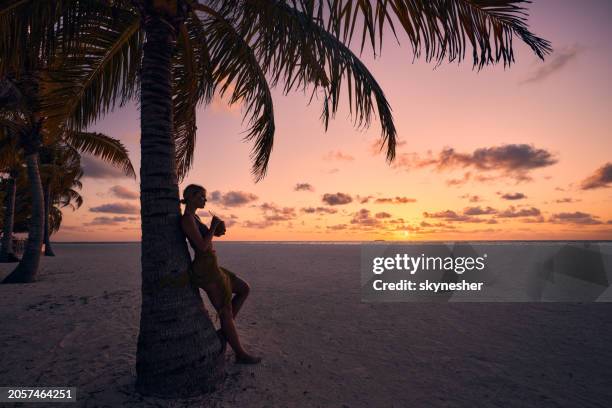 carefree woman enjoying in coconut drink on the beach at sunset. - meeru island stockfoto's en -beelden