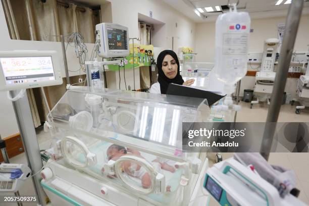 Warde al-Awawde, medical worker who took refuge in Deir al-Balah from Bureij refugee camp, treat the Palestinian patients at Al-Aqsa Martyrs Hospital...