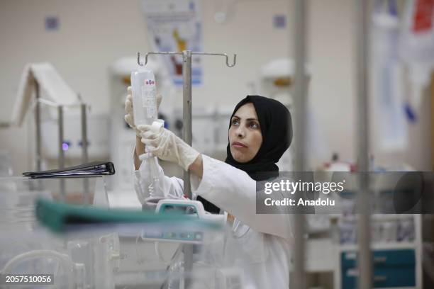 Warde al-Awawde, medical worker who took refuge in Deir al-Balah from Bureij refugee camp, treat the Palestinian patients at Al-Aqsa Martyrs Hospital...