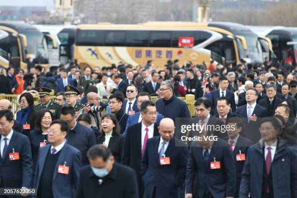 Members of the 14th National Committee of the Chinese People's Political Consultative Conference walk to the Great Hall of the People before the...