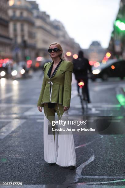 Palina Kozyrava seen wearing Loewe black sunglasses, black large flower earrings, Femif green / black elegant pleated blazer jacket, matching Femif...