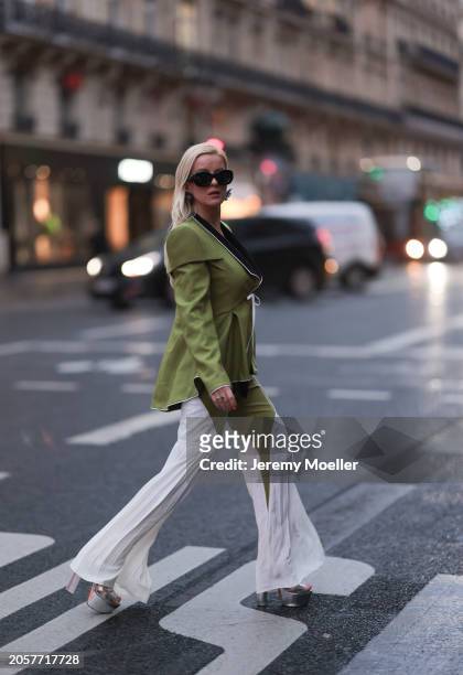 Palina Kozyrava seen wearing Loewe black sunglasses, black large flower earrings, Femif green / black elegant pleated blazer jacket, matching Femif...