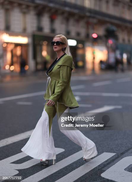 Palina Kozyrava seen wearing Loewe black sunglasses, black large flower earrings, Femif green / black elegant pleated blazer jacket, matching Femif...