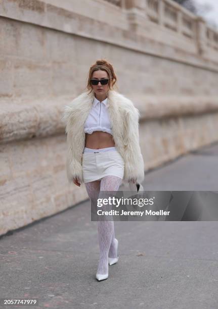 Damla Kalaycık seen wearing Chanel black sunglasses, Miu Miu silver diamond pendant earrings, Jacquemus white zip cropped shirt, Miu Miu creamy white...