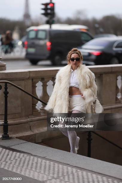 Damla Kalaycık seen wearing Chanel black sunglasses, Miu Miu silver diamond pendant earrings, Jacquemus white zip cropped shirt, Miu Miu creamy white...