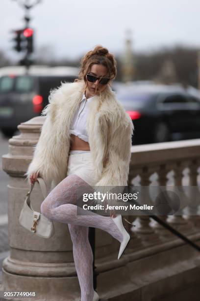 Damla Kalaycık seen wearing Chanel black sunglasses, Miu Miu silver diamond pendant earrings, Jacquemus white zip cropped shirt, Miu Miu creamy white...