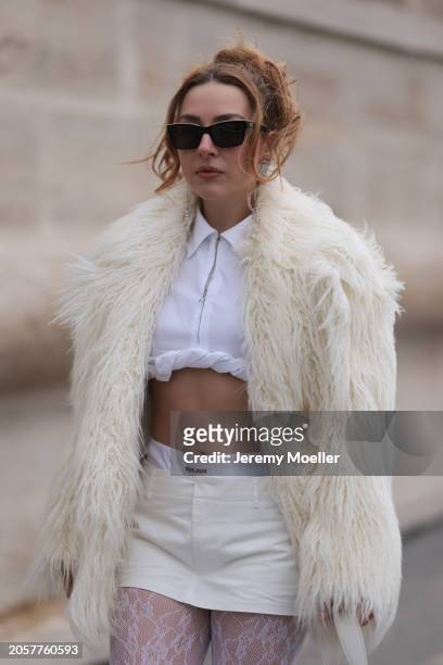 Damla Kalaycık seen wearing Chanel black sunglasses, Miu Miu silver diamond pendant earrings, Jacquemus white zip cropped shirt, Miu Miu creamy white...