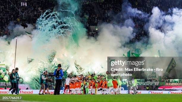 Fans of VfL Wolfsburg ignite pyro and color pots ahead of the Bundesliga match between VfL Wolfsburg and VfB Stuttgart at Volkswagen Arena on March...