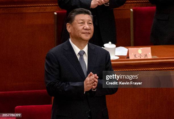Chinese President Xi Jinping clasps his hands as he stands at the opening session of the CPPCC, or Chinese Peoples Political Consultative Conference,...