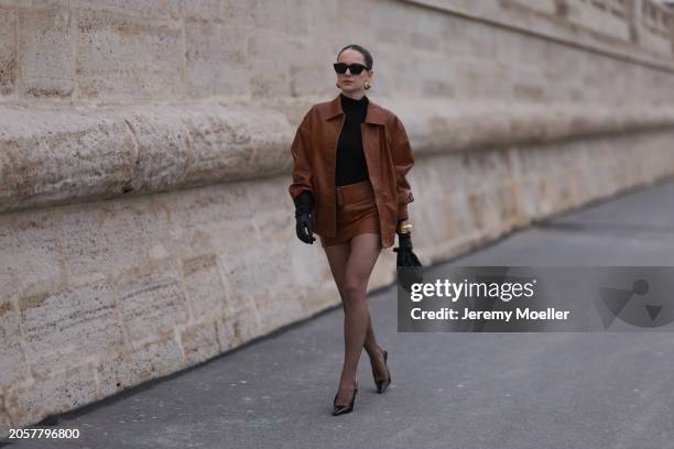 Berna Bilbey seen wearing YSL black sunglasses, gold earrings, COS black turtleneck top, Lioness brown oversized leather jacket, matching Lioness...