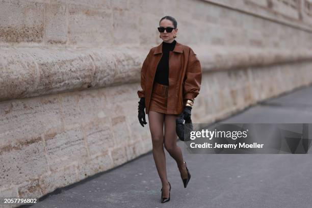 Berna Bilbey seen wearing YSL black sunglasses, gold earrings, COS black turtleneck top, Lioness brown oversized leather jacket, matching Lioness...