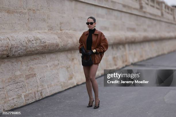 Berna Bilbey seen wearing YSL black sunglasses, gold earrings, COS black turtleneck top, Lioness brown oversized leather jacket, matching Lioness...