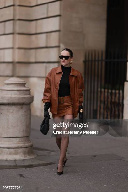 Berna Bilbey seen wearing YSL black sunglasses, gold earrings, COS black turtleneck top, Lioness brown oversized leather jacket, matching Lioness...