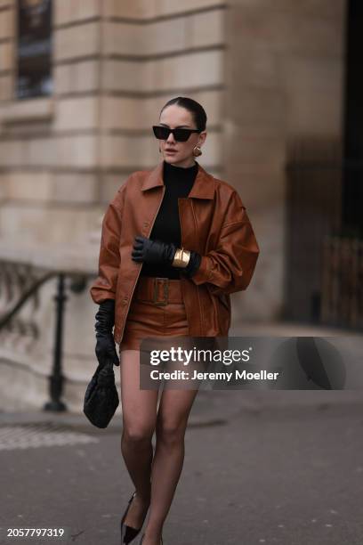 Berna Bilbey seen wearing YSL black sunglasses, gold earrings, COS black turtleneck top, Lioness brown oversized leather jacket, matching Lioness...