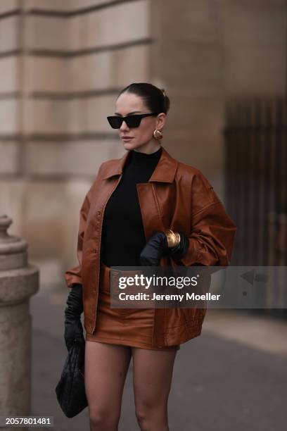 Berna Bilbey seen wearing YSL black sunglasses, gold earrings, COS black turtleneck top, Lioness brown oversized leather jacket, matching Lioness...