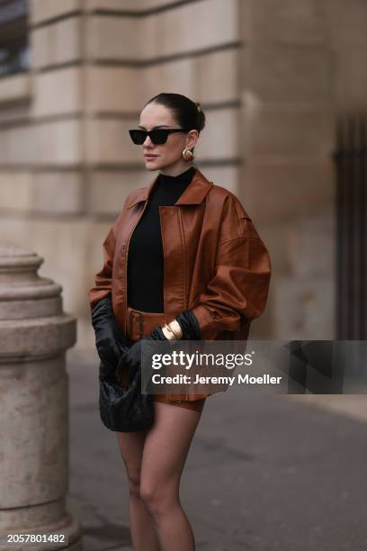 Berna Bilbey seen wearing YSL black sunglasses, gold earrings, COS black turtleneck top, Lioness brown oversized leather jacket, matching Lioness...