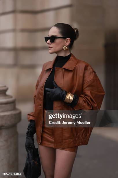 Berna Bilbey seen wearing YSL black sunglasses, gold earrings, COS black turtleneck top, Lioness brown oversized leather jacket, matching Lioness...