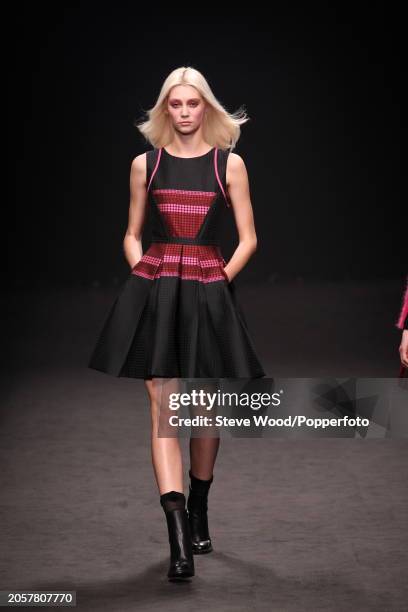 Model walks the runway at the Byblos show during Milan Fashion Week Autumn/Winter 2016/17, she wears a short black sleeveless dress with full skirt...