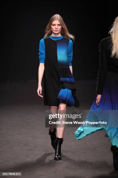 Model walks the runway at the Byblos show during Milan Fashion Week Autumn/Winter 2016/17, she wears a turquoise ribbed top under a sleeveless black...