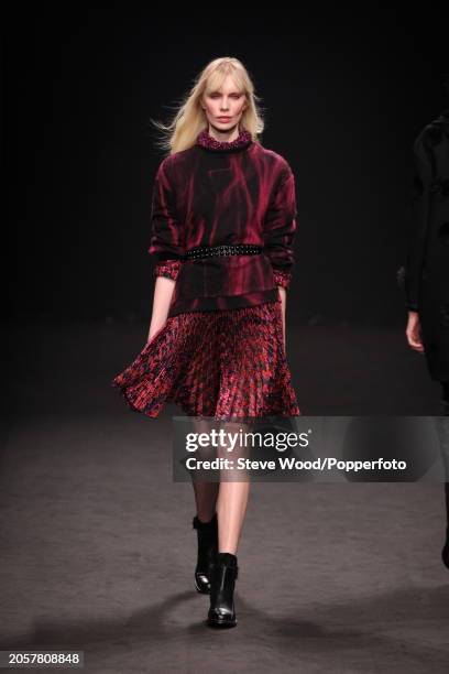 Model walks the runway at the Byblos show during Milan Fashion Week Autumn/Winter 2016/17, she wears a floral print burgundy dress with pleated skirt...