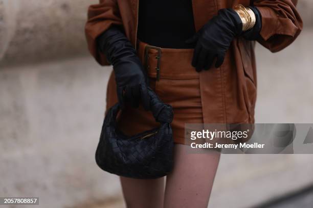 Berna Bilbey seen wearing COS black turtleneck top, Lioness brown oversized leather jacket, matching Lioness brown leather belted short skirt, gold...