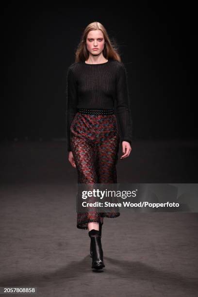 Model walks the runway at the Byblos show during Milan Fashion Week Autumn/Winter 2016/17, she wears a burgundy and aqua print midi skirt with...