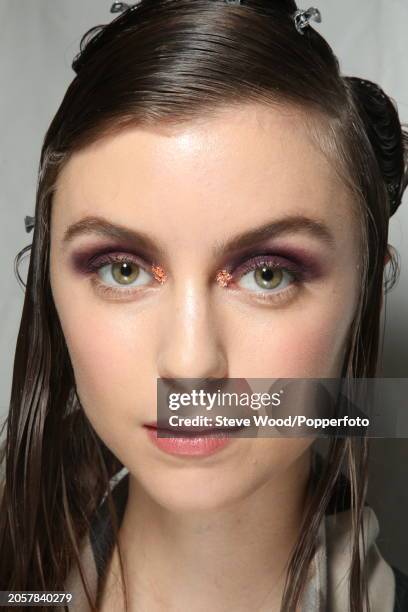 Backstage at the Cividini show during Milan Fashion Week Autumn/Winter 2016/17, close up of a model with her hair gelled and wearing metallic eye...