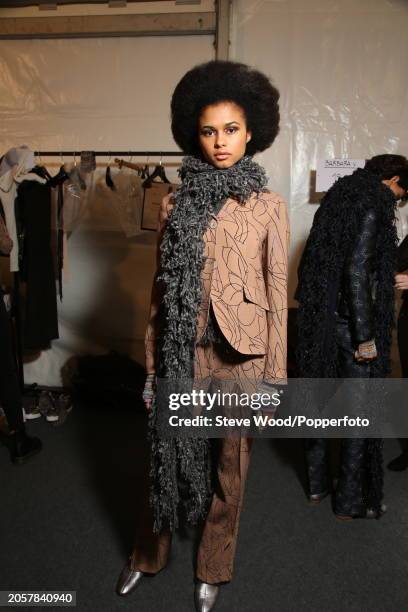 Backstage at the Cividini show during Milan Fashion Week Autumn/Winter 2016/17, a model wears a fitted camel coloured trouser suit in a scribbled...