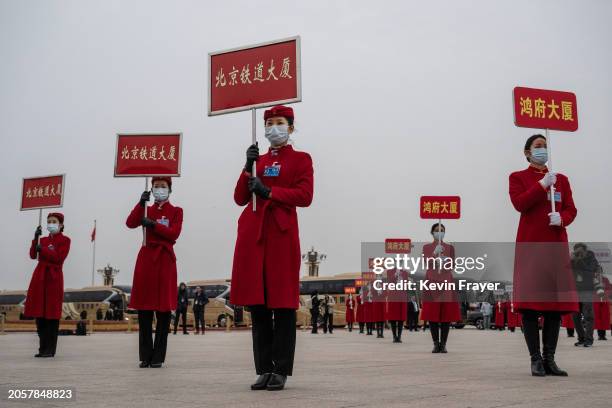 Hostesses wait to direct delegates to their buses and hotels after the opening session of the CPPCC, or Chinese Peoples Political Consultative...